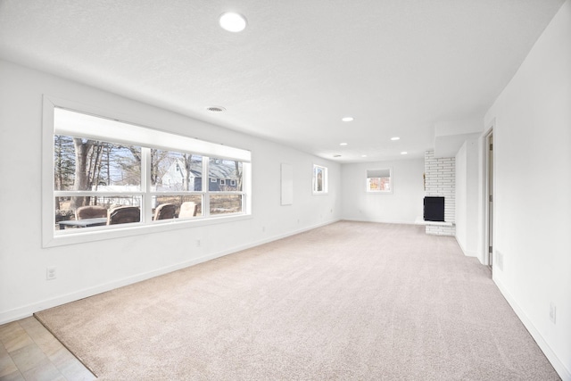 unfurnished living room with recessed lighting, a fireplace, baseboards, and carpet floors