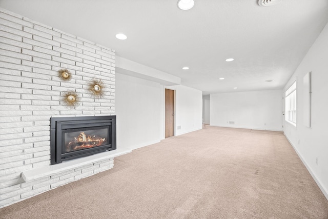 unfurnished living room featuring recessed lighting, baseboards, a brick fireplace, and carpet flooring