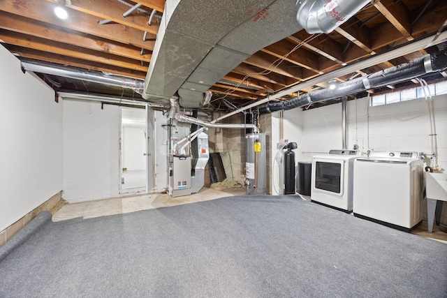 basement featuring heating unit, separate washer and dryer, and water heater