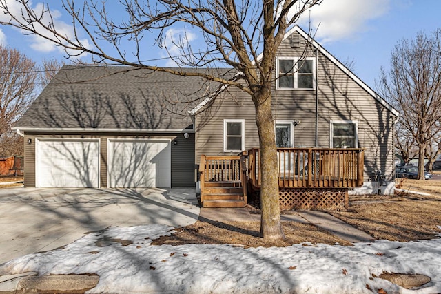 view of front facade with a wooden deck, concrete driveway, and a shingled roof