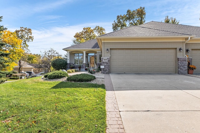 view of front of home with a garage, driveway, a front lawn, and a shingled roof