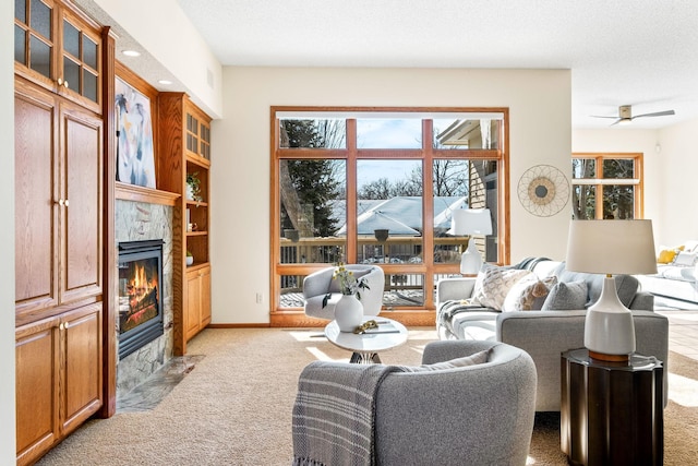 interior space with a tile fireplace, baseboards, a textured ceiling, and light colored carpet