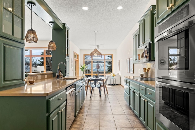 kitchen with hanging light fixtures, green cabinetry, and a sink