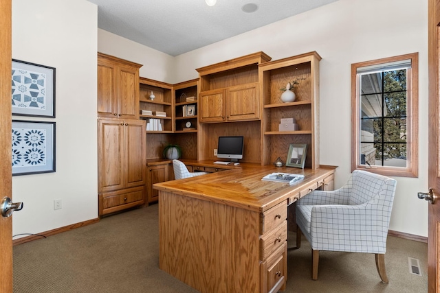 office space with visible vents, dark carpet, and baseboards