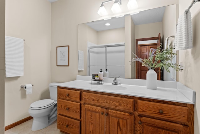 bathroom with tile patterned flooring, toilet, vanity, baseboards, and a shower stall