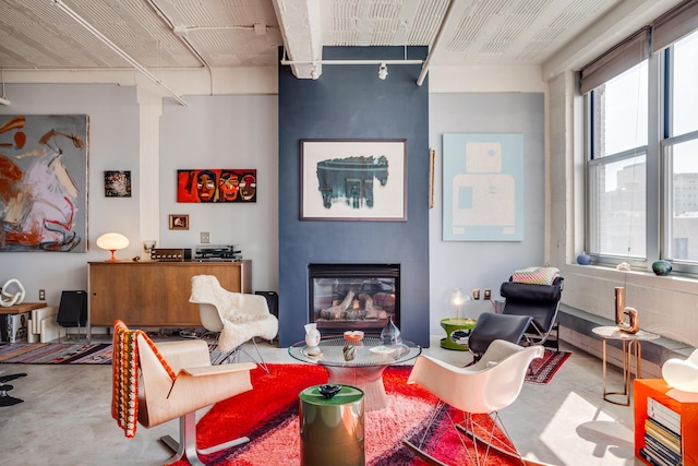 living room featuring a large fireplace and concrete floors