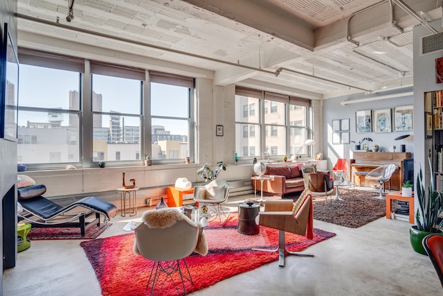 interior space with plenty of natural light, finished concrete flooring, visible vents, and a city view