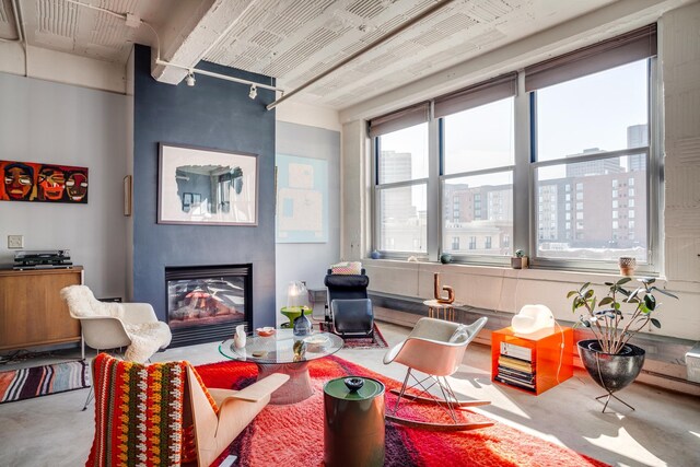 225 9th St E Unit 504, Saint Paul, MN 55101 - living area featuring rail lighting, finished concrete flooring, a large fireplace, and a city view