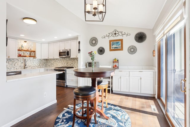 kitchen featuring open shelves, stainless steel appliances, dark wood-type flooring, white cabinetry, and vaulted ceiling