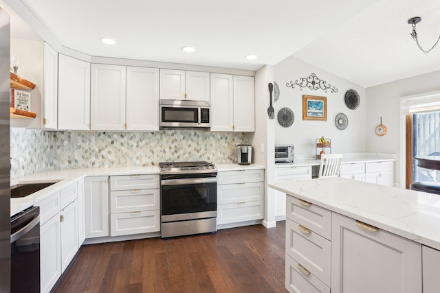 kitchen with appliances with stainless steel finishes, dark wood-style flooring, white cabinetry, open shelves, and backsplash