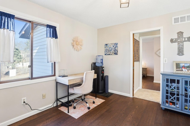 office area with visible vents, baseboards, and wood finished floors