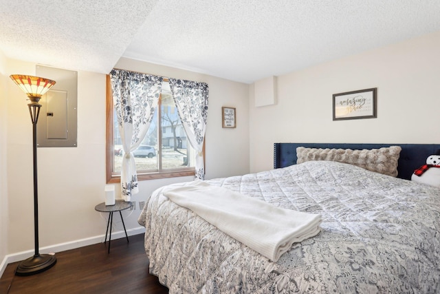 bedroom with dark wood-style floors, electric panel, a textured ceiling, and baseboards