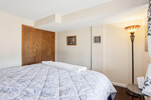 bedroom featuring dark wood-type flooring and a textured ceiling