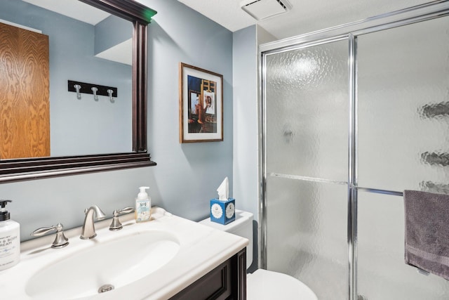 full bathroom with visible vents, a shower stall, toilet, and vanity