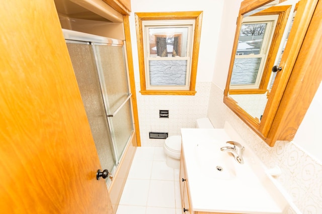 bathroom featuring a wainscoted wall, tile walls, toilet, vanity, and tile patterned floors