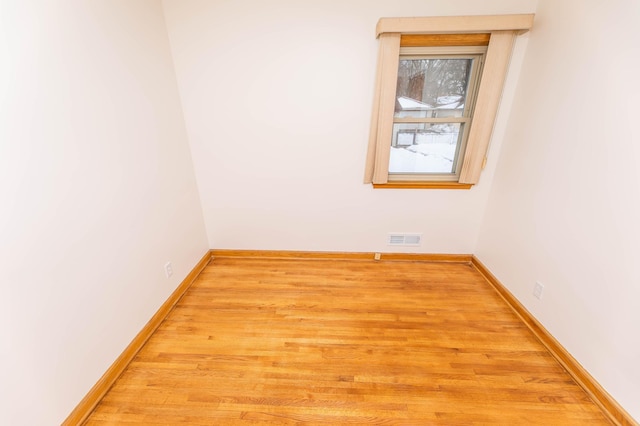 unfurnished room featuring visible vents, baseboards, and wood finished floors