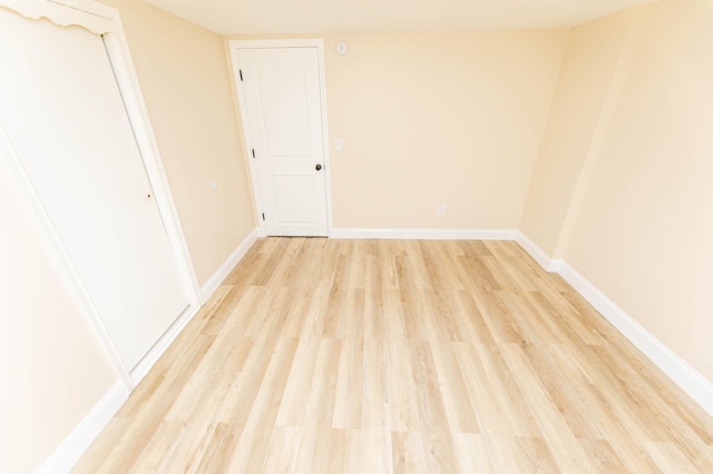 spare room with light wood finished floors and baseboards