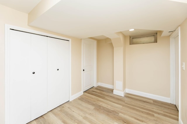 unfurnished bedroom with light wood-type flooring, a closet, baseboards, and recessed lighting