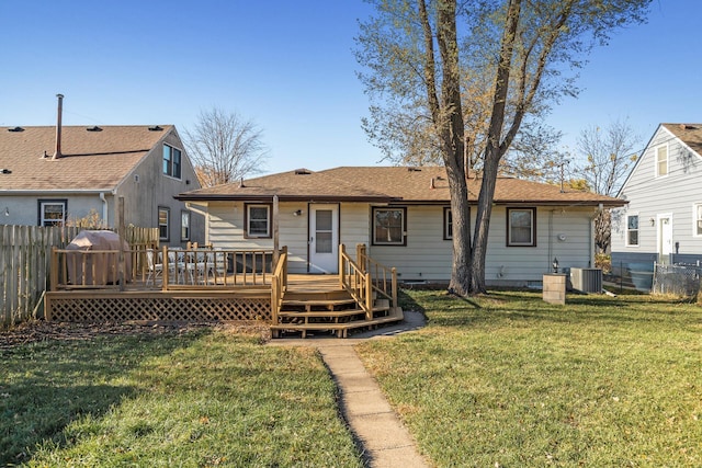 rear view of property with fence, a lawn, a wooden deck, and central air condition unit