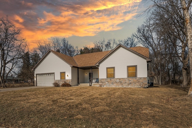 ranch-style house with a garage, stone siding, a yard, and driveway