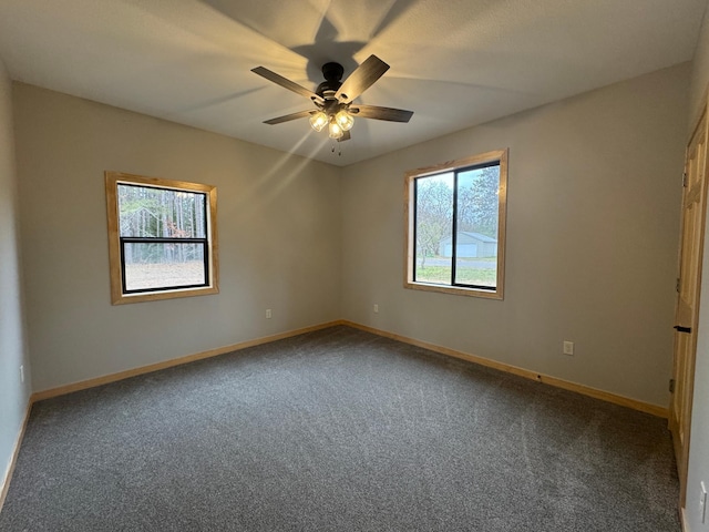 empty room with carpet, baseboards, and a ceiling fan