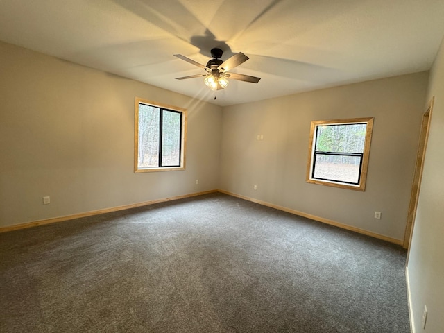 carpeted empty room featuring ceiling fan and baseboards