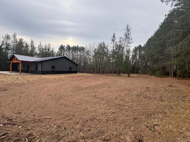 view of yard featuring a garage and a forest view