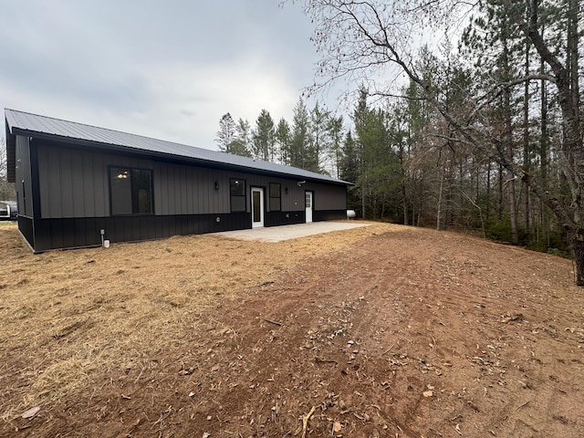 back of property featuring metal roof and board and batten siding