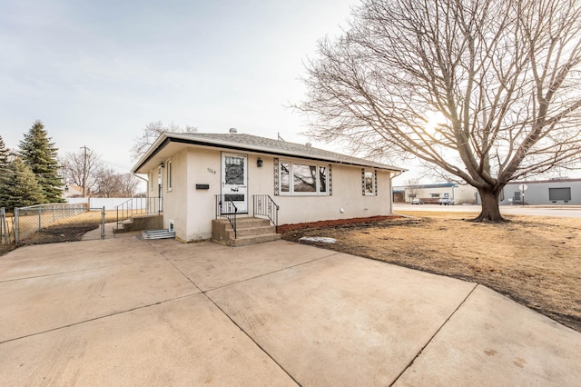 view of front of home with a gate, stucco siding, and fence