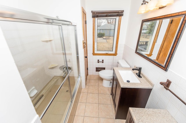 bathroom featuring vanity, tile walls, a shower stall, and tile patterned flooring