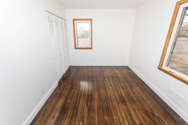 interior space with wood finished floors, baseboards, and visible vents