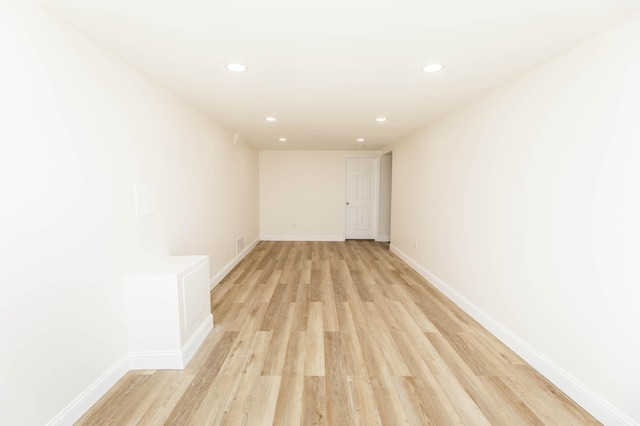 unfurnished room featuring recessed lighting, light wood-style floors, and baseboards