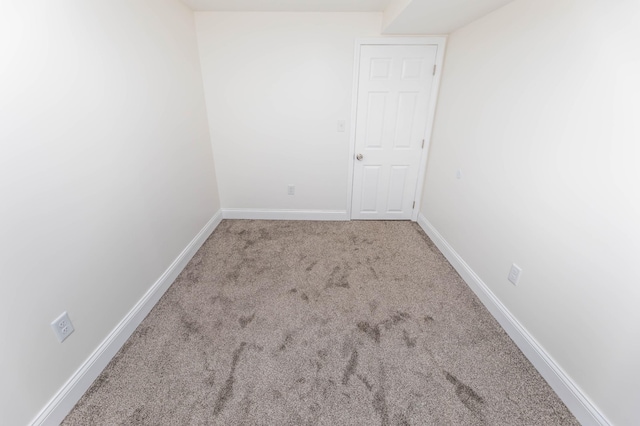 carpeted spare room featuring baseboards