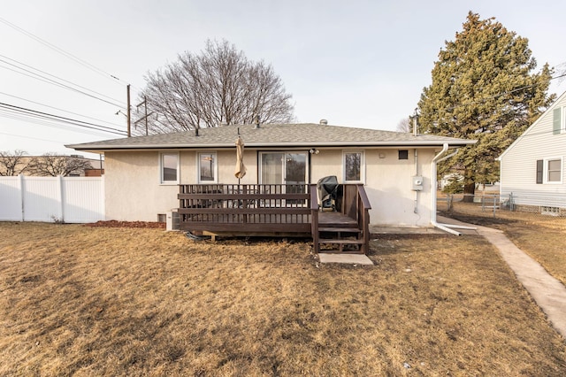 back of property with fence, a lawn, and stucco siding