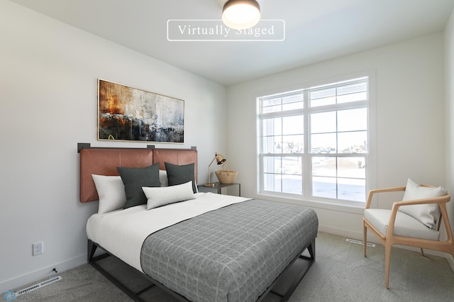 carpeted bedroom featuring baseboards and multiple windows