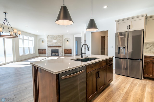 kitchen with stainless steel appliances, a sink, light wood-type flooring, light countertops, and recessed lighting