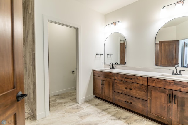 bathroom with double vanity and baseboards