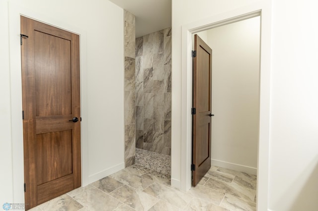 full bathroom featuring walk in shower and baseboards