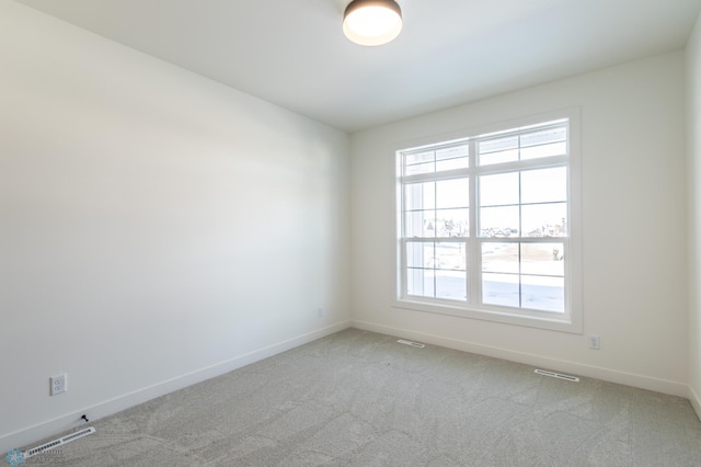 carpeted spare room featuring baseboards and healthy amount of natural light