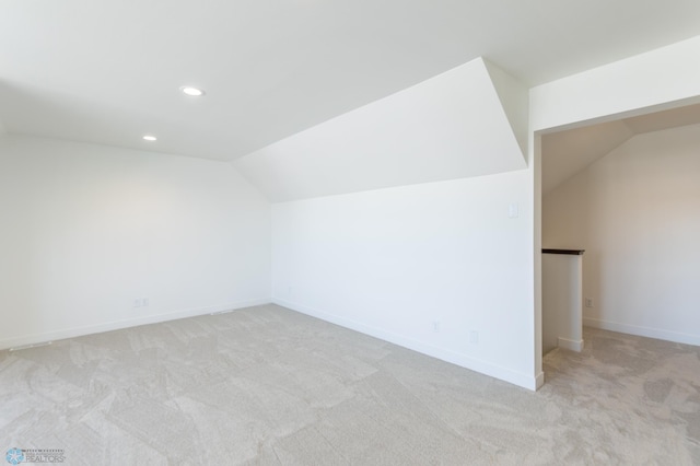 additional living space featuring lofted ceiling, light carpet, baseboards, and recessed lighting