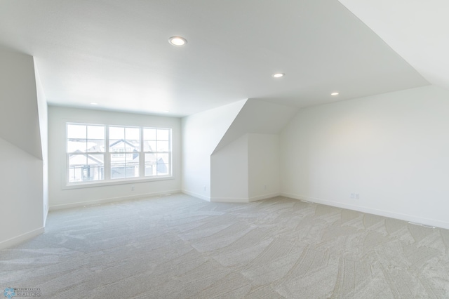 additional living space with recessed lighting, light carpet, baseboards, and lofted ceiling