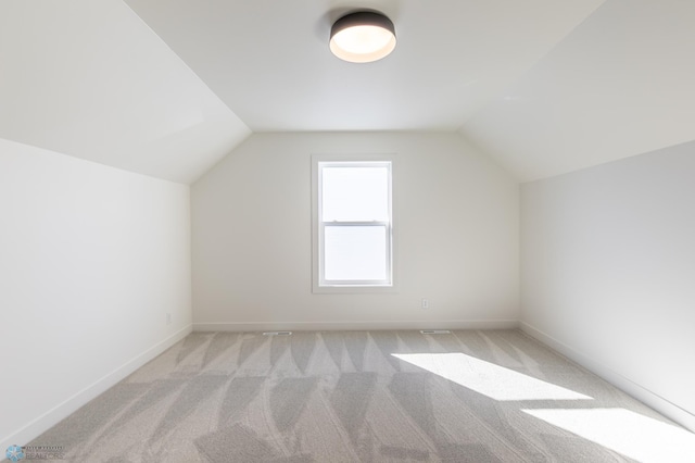 additional living space with carpet floors, lofted ceiling, and baseboards