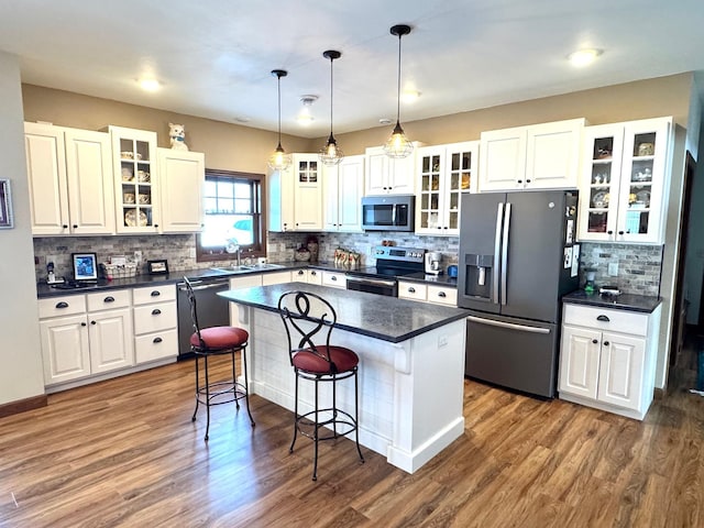 kitchen with stainless steel appliances, dark countertops, and glass insert cabinets