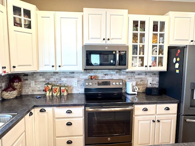 kitchen featuring glass insert cabinets, appliances with stainless steel finishes, and white cabinets