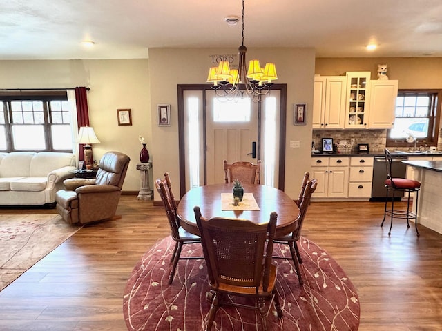 dining room featuring baseboards, a chandelier, and wood finished floors