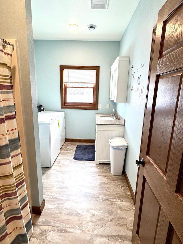 laundry area featuring cabinet space, visible vents, washing machine and dryer, a sink, and baseboards