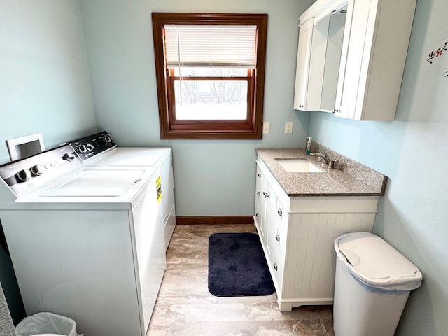 laundry area with washer and dryer, cabinet space, a sink, and baseboards