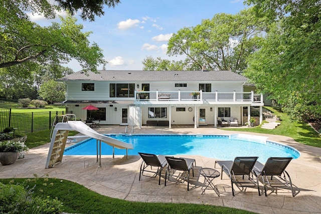 view of swimming pool featuring a fenced in pool, fence, a water slide, and a patio