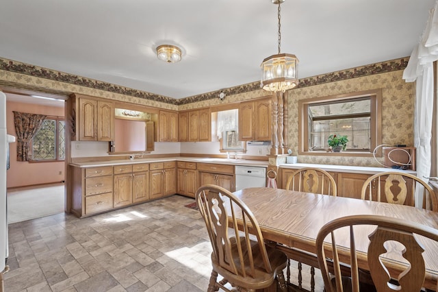 2905 Lake Blvd N, Saint Paul, MN 55109 - kitchen featuring wallpapered walls, a sink, light countertops, a chandelier, and baseboards