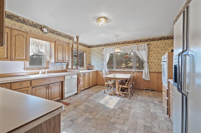 2905 Lake Blvd N, Saint Paul, MN 55109 - kitchen with white appliances, wallpapered walls, wainscoting, a sink, and light countertops